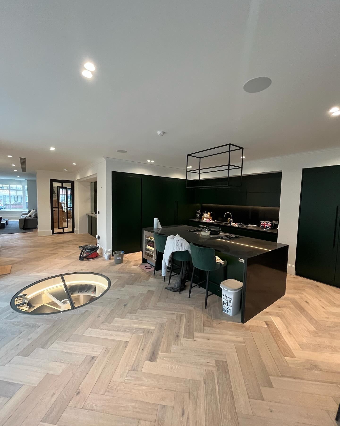 Dark green kitchen with circular wine cellar floor hatch, Essex